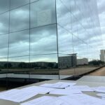 Edifício da Caesb em Brasília com documentos de concurso espalhados, indicando suspeitas de falhas.