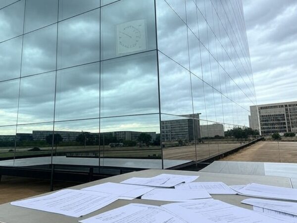 Edifício da Caesb em Brasília com documentos de concurso espalhados, indicando suspeitas de falhas.