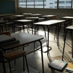 Fachada de escola pública em Brasília com documentos espalhados, representando instabilidade na educação do DF.