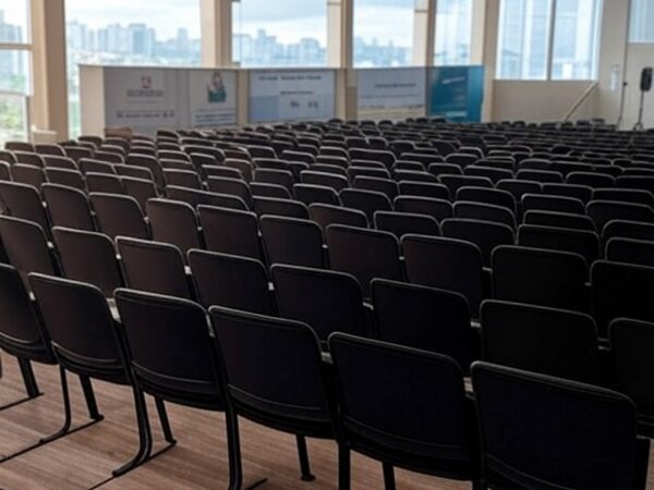 Auditório vazio após conferência sobre segurança pública no Brasil, com palco e cadeiras arrumadas, transmitindo incerteza no impacto real.