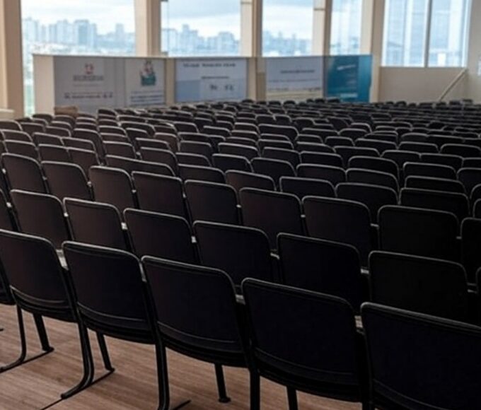 Auditório vazio após conferência sobre segurança pública no Brasil, com palco e cadeiras arrumadas, transmitindo incerteza no impacto real.