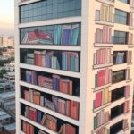 Prédio do Sesc com murais culturais e contraste de favela ao fundo, simbolizando 80 anos e questionamento sobre impacto na desigualdade no Brasil.