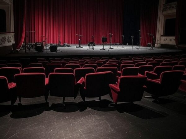 Teatro brasileiro com palco preparado para estreia de musical, representando transição de carreira com dúvidas.
