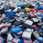 Pilha de lixo eletrônico em aterro no Brasil, criticando consumismo e redefinindo luxo como tempo de qualidade.