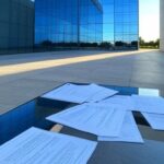 Edifício do CRF-DF em Brasília com relógio e documentos, representando prazos apertados e críticas por transparência em concurso.