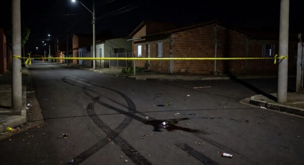 Rua vazia à noite em Sobradinho, DF, com marcas de briga no chão, representando tragédia local.