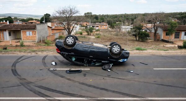 Carro Ônix capotado em acidente na QR 125, Samambaia Sul, DF, com destroços na rua urbana.