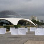 Fachada da CLDF em Brasília com fitas roxas simbolizando violência contra mulheres no DF.