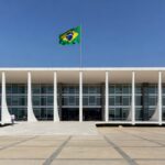Edifício do STF em Brasília representando decisão judicial sobre mensagens, com documentos e smartphone.