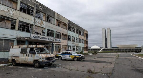 Hospital público deteriorado e viatura policial em Brasília, representando colapso na saúde e segurança do DF.