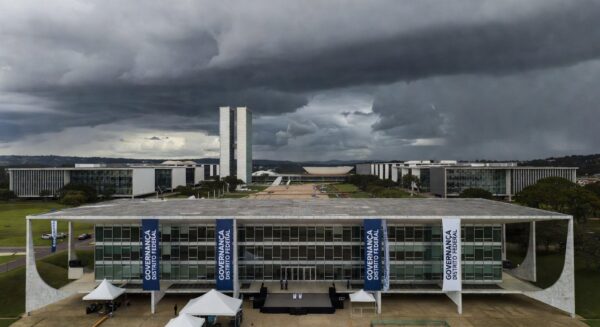 Fachada da Câmara Legislativa do DF sob nuvens escuras, expondo falhas na governança de Brasília.