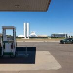 Posto de gasolina em Brasília com preços altos de combustíveis e veículos de fiscalização, representando operação contra abusos no DF.