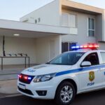 Viatura da polícia em frente a residência em Brasília, com armas apreendidas por violência doméstica e posse irregular.