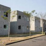 Rua em Samambaia com vidros quebrados e viaturas policiais após tiroteio.