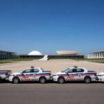Imagem da Esplanada dos Ministérios em Brasília com viaturas da Polícia Militar do DF e Congresso Nacional ao fundo, representando gestão local de segurança.