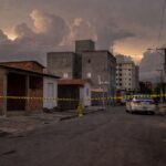 Rua em Samambaia com fita de isolamento policial e viatura, representando cena de crime no Distrito Federal.