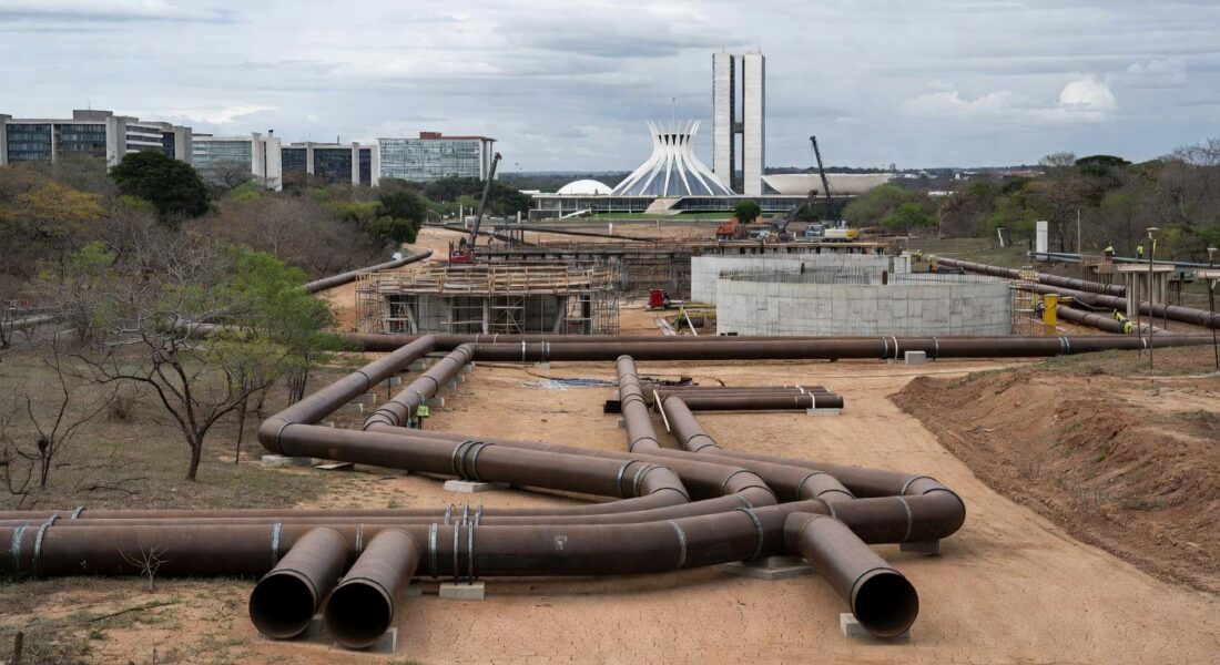 Obras de abastecimento de água no DF com tubulações em terreno seco, destacando risco de escassez hídrica.