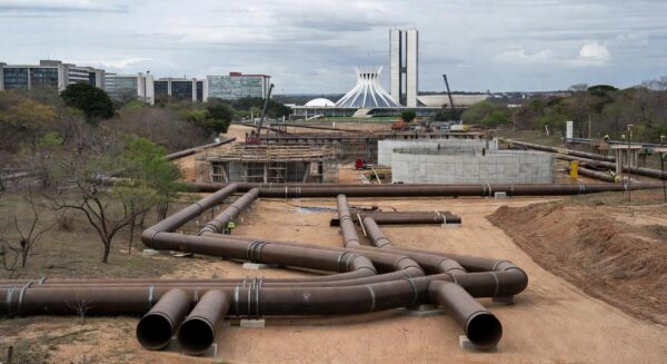Obras de abastecimento de água no DF com tubulações em terreno seco, destacando risco de escassez hídrica.