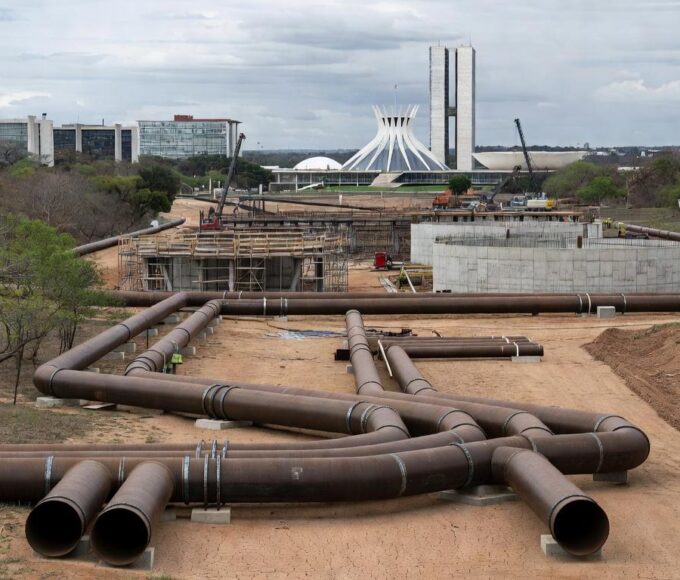 Obras de abastecimento de água no DF com tubulações em terreno seco, destacando risco de escassez hídrica.