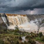 Barragem de Santa Maria transbordando no DF, expondo riscos de inundações após quatro anos.