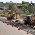 Obras de pavimentação na Avenida Contorno em Vicente Pires, Brasília, com máquinas e barreiras na via