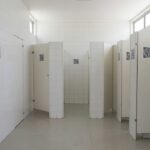 Adesivos com QR Code em banheiro público do DF divulgando o programa Direito Delas