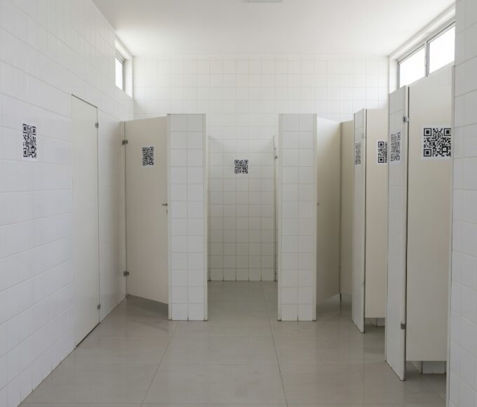Adesivos com QR Code em banheiro público do DF divulgando o programa Direito Delas